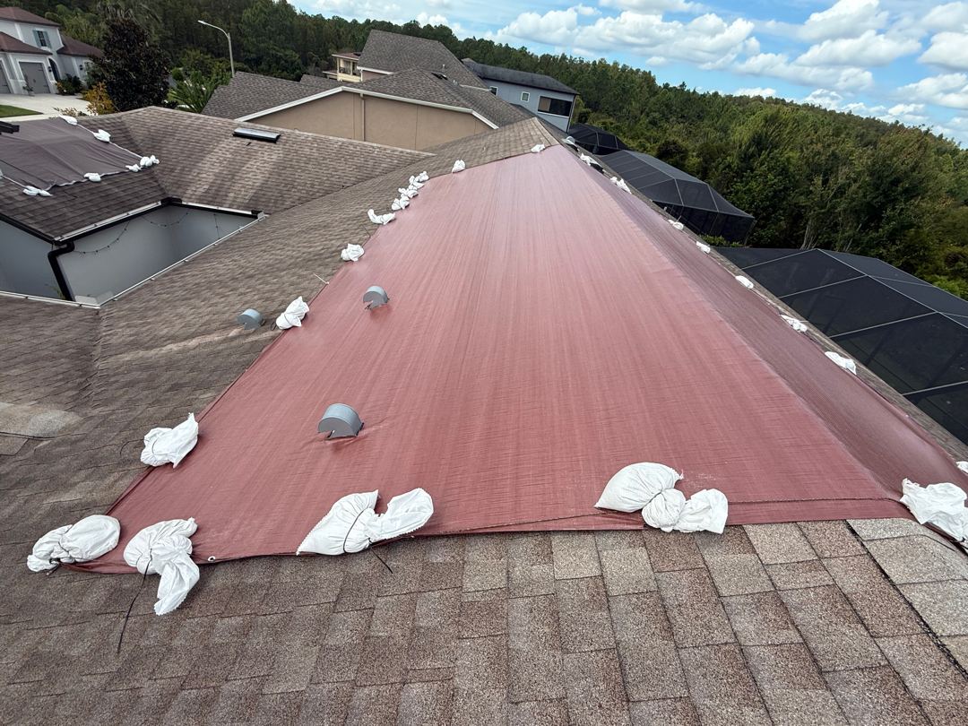 Roof secured with non-invasive sandbag tarp system after Emergency Tarps On Time install
