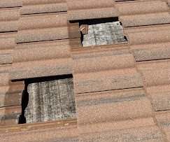 Broken roof tiles with exposed underlayment before emergency tarp install