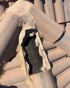 Close-up of cracked tile and exposed decking damage