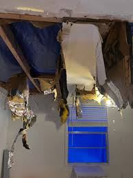 Interior ceiling collapsed with exposed framing and insulation from active roof leak